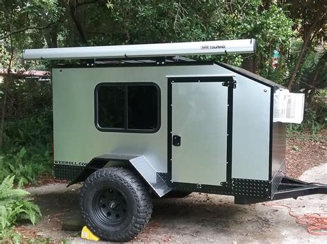 An Off Road Camper Trailer Parked In The Woods