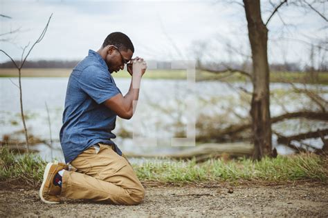 A Man Kneeling In Prayer Outdoors — Photo — Lightstock