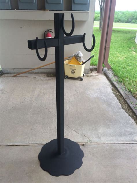 A Black Metal Pole With Two Hooks On It S Sides And A Bucket Next To It