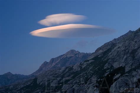 They are lenticular clouds formed when moist air is forced upwards near a mountain or volcano. Image: Lenticular cloud over mountain | Stock photo by JF ...