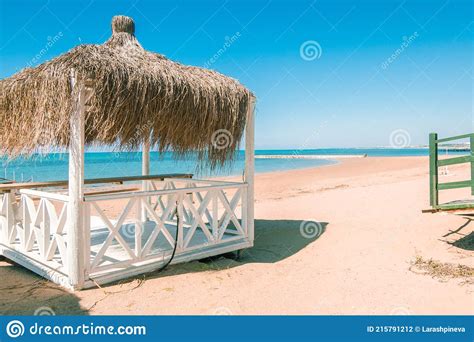 massage huts with thatched roof on sand beach along seaside luxury vacation resort spa stock