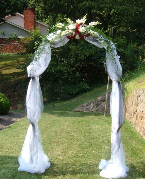 Wedding Arch Covered With Tulle And Accented With Flowers Metal