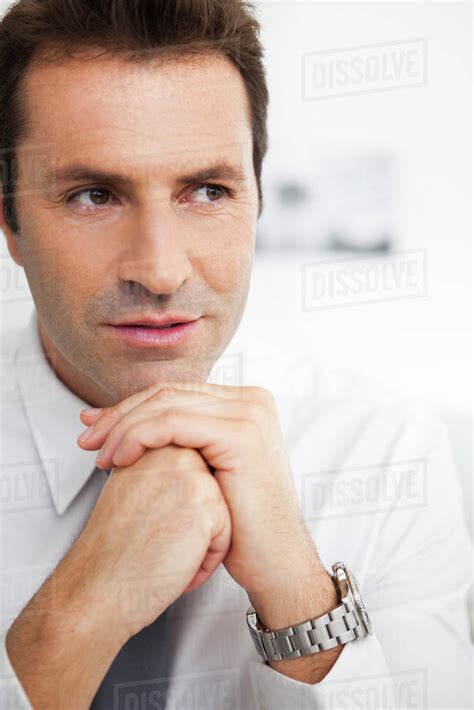 Businessman With Hands Clasped Under Chin Portrait Stock Photo