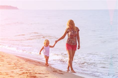 Madre Con La Hija Joven Que Camina A Lo Largo De La Playa Junto Foto De