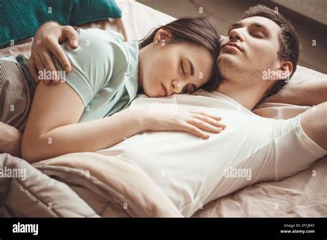 Adorable Couple Lying In Bed And Napping Together Embracing In A
