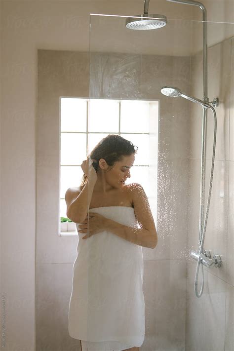 Young Woman In A Bathroom Wrapped In A White Towel After A Shower By Stocksy Contributor