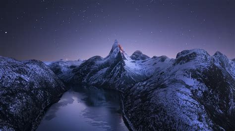 Norway Mountain With Snow And Peak Pond Under Starry Sky During