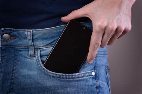 Premium Photo Smartphone In Hand In A Pocket In Jeans