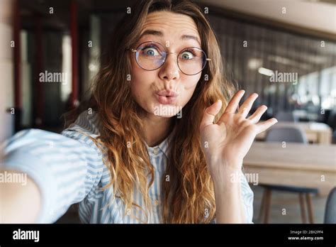 Image Of Amusing Beautiful Woman In Eyeglasses Waving Hand And Taking Selfie Photo In Lecture