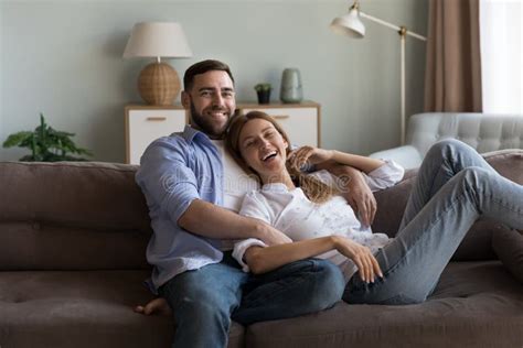 Couple Relaxing On Sofa Laughing Look At Camera Feel Happy Stock Photo