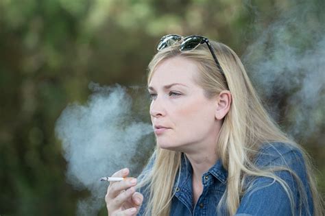 Beautiful Young Woman Smoking And Blowing Cigarette Smoke