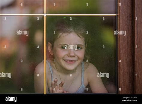 Happy Little Girl Looking Out Through Window Stock Photo Alamy