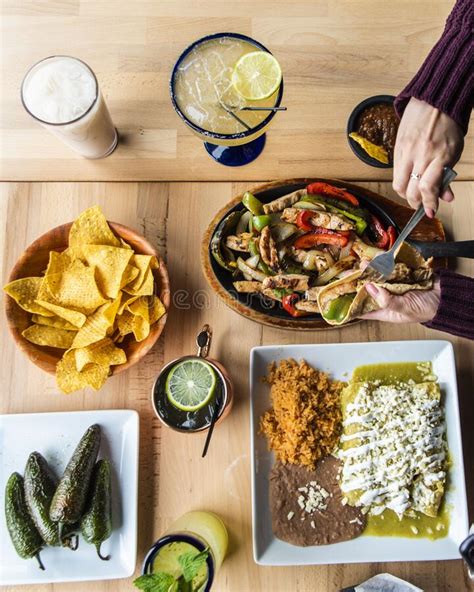 Woman Trying Fajita From A Wooden Table With Mexican Dishes Stock Image Image Of Jalapeno