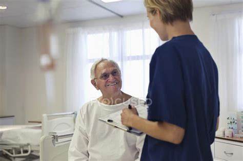 Nurse Talking With Older Patient In Hospital — Woman Smiling Stock
