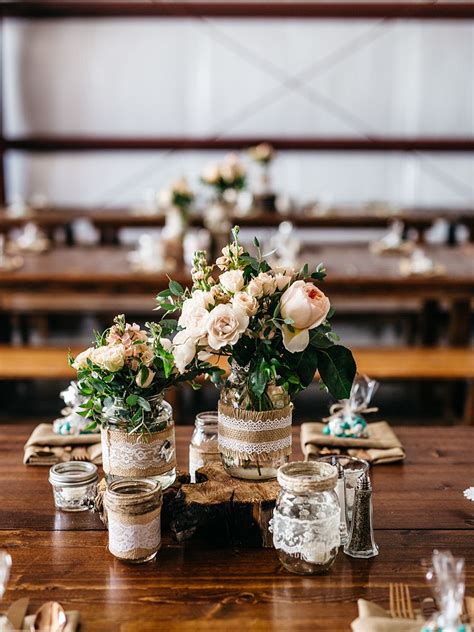 This table has gone for a symmetrical approach with two plants framing a display of three candles. Ideas & Advice by The Knot | Wedding centerpieces diy ...