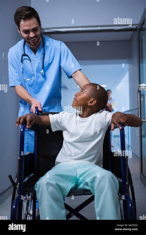 Male Nurse Interacting With Child Patient In Corridor Stock Photo Alamy