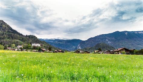 Free Photo Green Grass Field And Mountain Under White Clouds