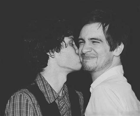Two Men Are Kissing Each Other In Black And White