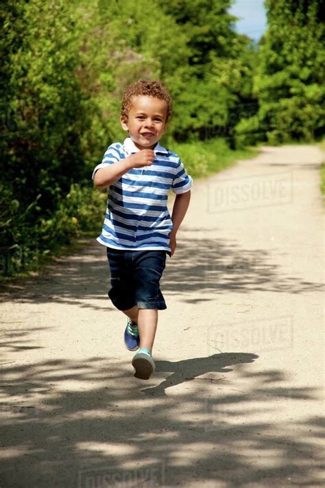 Portrait Of A Little Boy Running And Having Fun On A Sunny Day Stock