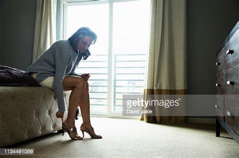 Mature Woman Sitting On Bed Putting On High Heels Photo Getty Images
