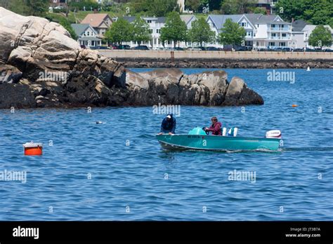 Fishermen In A Small Fishing Boat In Gloucester Harbor With The