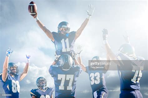 Teenage And Young Male American Football Team Celebrating On Pitch High