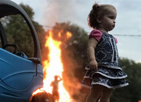 photo of girl standing stoically by fire is the latest and greatest internet meme