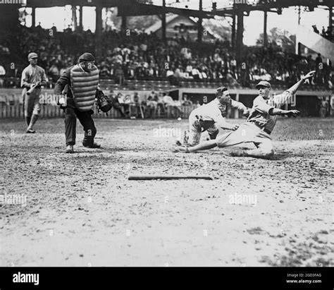 Umpire Makes The Call As The Catcher Applies Tag To Ball Player Sliding Into Home Plate During A