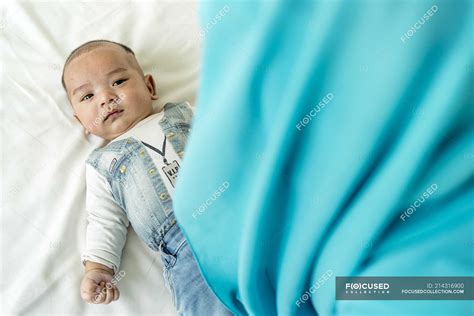 Baby Lying Down On The Bed Looking At The Camera — Three Quarters