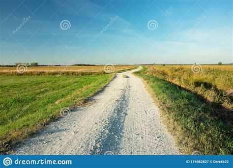 Gravel Road Through The Meadow Horizon And Blue Sky Stock Image