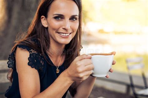 glimlachende jonge vrouw met een kop van koffie stock afbeelding afbeelding bestaande uit