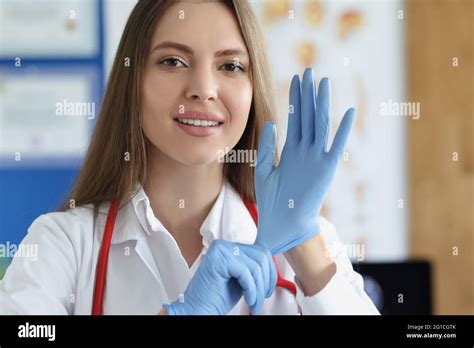 Portrait Of Female Doctor Putting On Medical Gloves Stock Photo Alamy