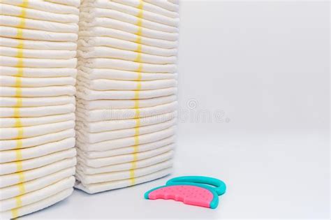 Stack Of Baby Disposable Diapers And Pacifier Over White Background
