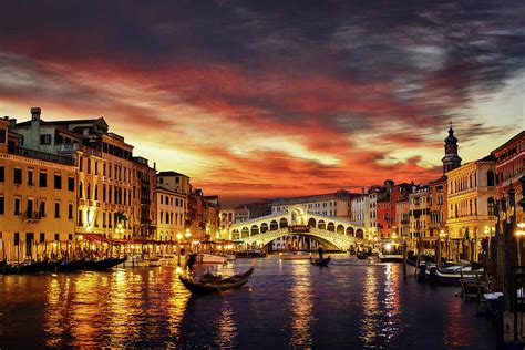 Ponte Rialto And Gondola On Water Reflecting Sunset Colors In Venice