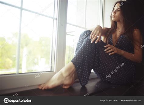 jeune femme sur rebord de fenêtre image libre de droit par xload © 169225450