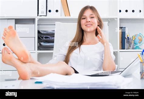 Portrait Of Young Businesswoman Relaxing In Office With Bare Feet On