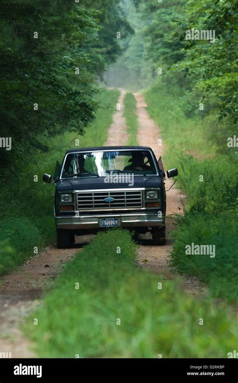Old Pickup Truck Driving Down A Dirt Road In The Forest Columbus