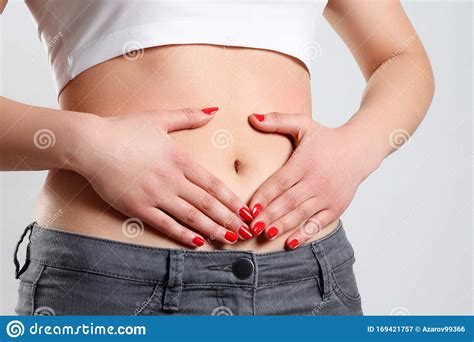 A Young Woman Massages Her Stomach With Two Hands Isolated On White