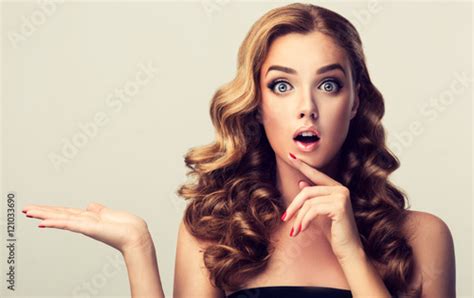 Woman Surprise Showing Product Beautiful Girl With Curly Hair Pointing To The Side Presenting