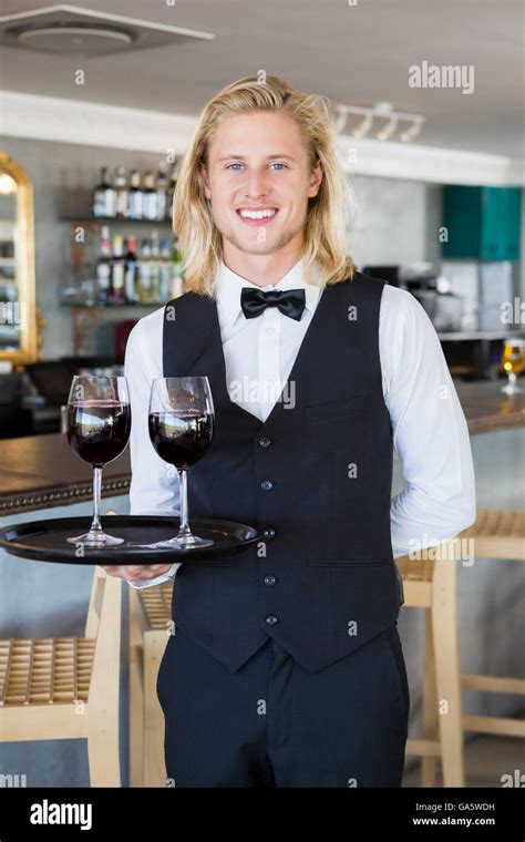 Portrait Of Waiter Holding Tray With Glasses Of Red Wine Stock Photo