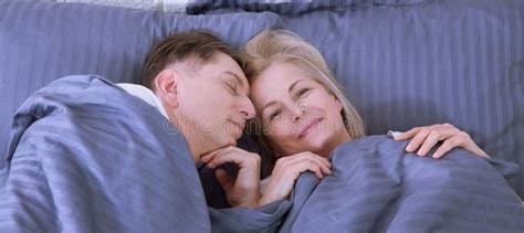 couple in bed man and woman are enjoying spending time together while lying in bed happy