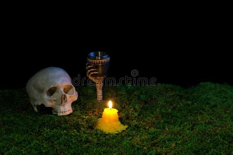 Halloween Human Skull Goblet And Candles Glowing In The Dark On Stock