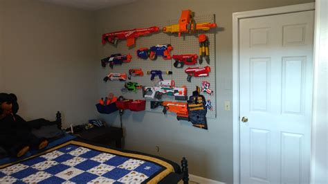 Space out 2 pegs at approximately the same length as the nerf gun and hang the gun over to hide your nerf guns from view, attach coat rack hangers to the sides of a cabinet with screws or anchors. Pin on aidens Nerf gun storage ideas