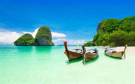 krabi island thailand beach ocean turquoise water boats coast rocks blue sky tropical landscape