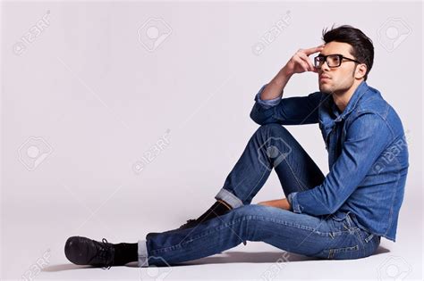 Stock Photo Side View Of A Casual Fashion Man Sitting On Gray