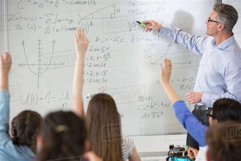 Male Teacher Leading Physics Lesson At Whiteboard In Classroom Stock