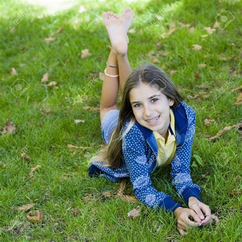 Portrait Of Smiling Tween Girl Lying On Grass Smiling To Camera Stock