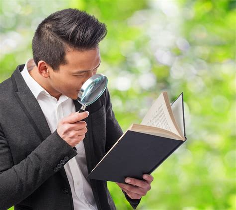 Detective Leyendo Un Libro Con Una Lupa Foto Gratis