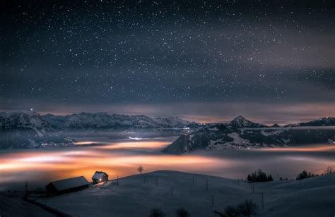 Wonderful Night Scenery Of A House Above The Clouds In The Swiss Alps