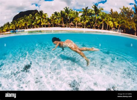 Attractive Woman Swimming Underwater In Transparent Blue Ocean At